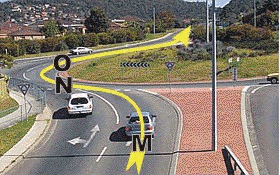 你在右道正准备穿过这个转盘路直行。你应该在什么时候打左转灯开出转盘路？