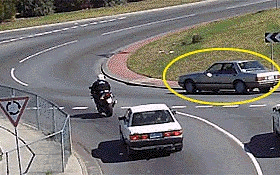 摩托车驾驶人想穿过这个转盘路直行。他应该警惕图中划圈的这辆车，因为这辆车 -